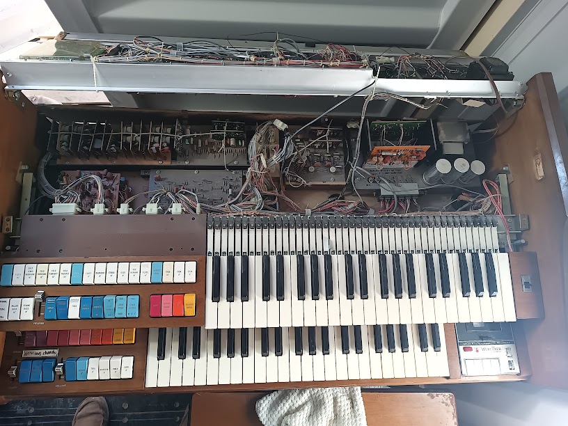 Deepest view into the console — upper circuit boards fully exposed with large electrolytic caps and multiple board assemblies