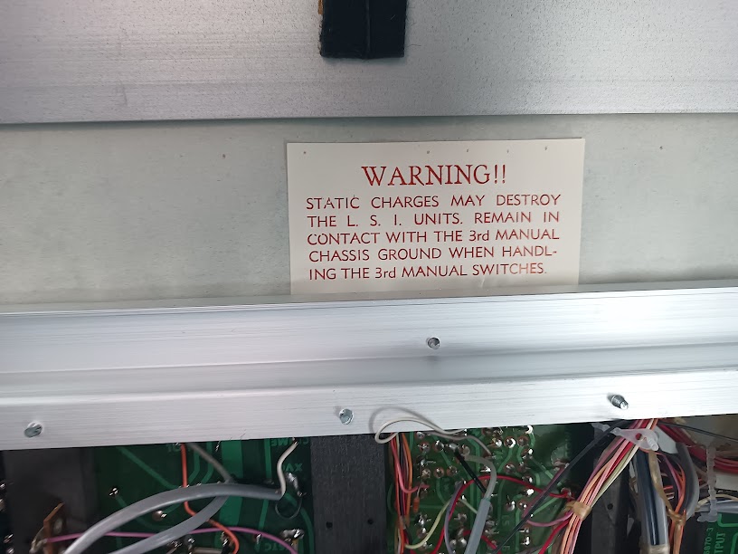 Factory warning label: "WARNING!! STATIC CHARGES MAY DESTROY THE L.S.I. UNITS. REMAIN IN CONTACT WITH THE 3rd MANUAL CHASSIS GROUND WHEN HANDLING THE 3rd MANUAL SWITCHES."